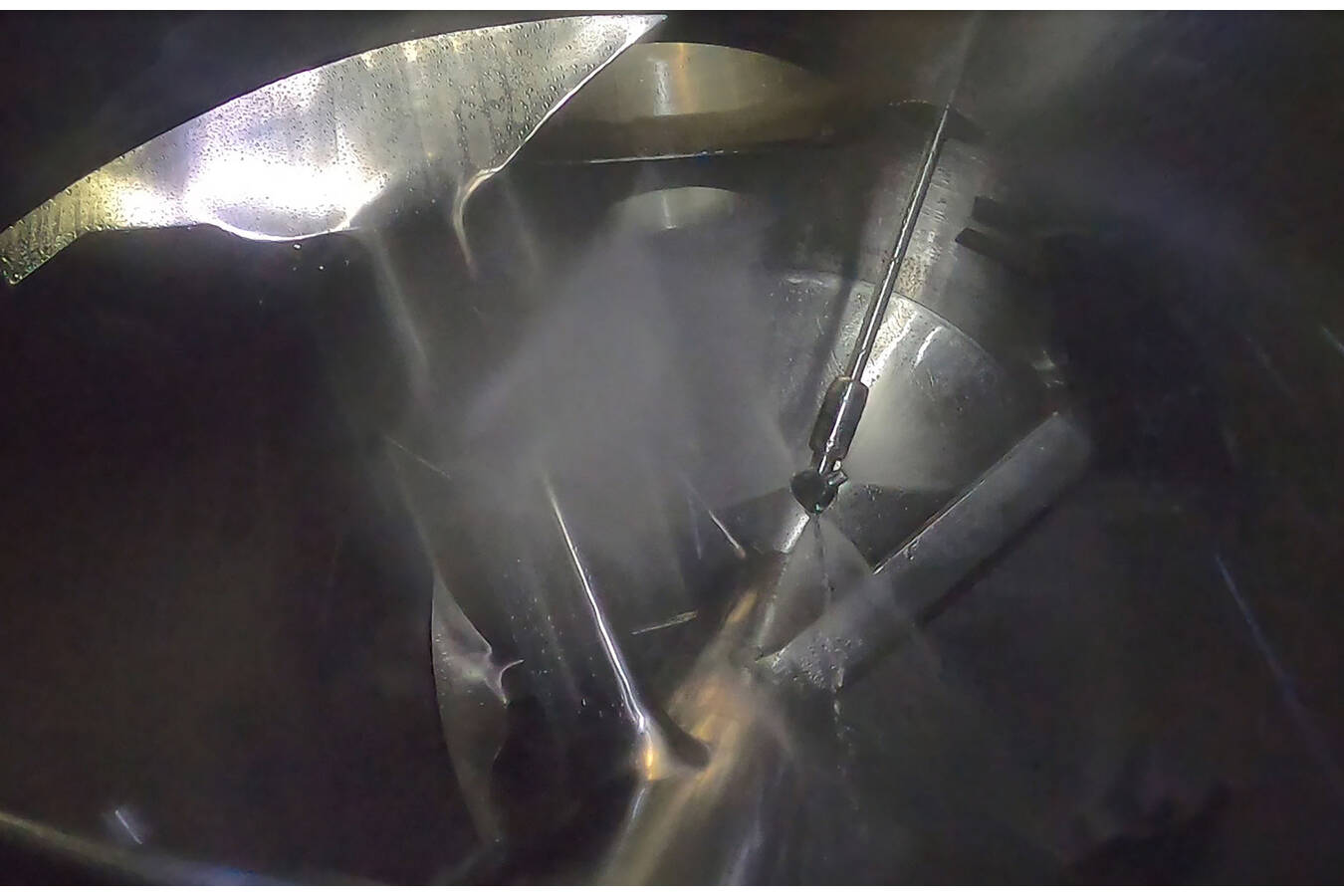Rotating flat fan cleaning nozzle in a 10.000 l Lödige Ploughshare®-Mixer in operation. 